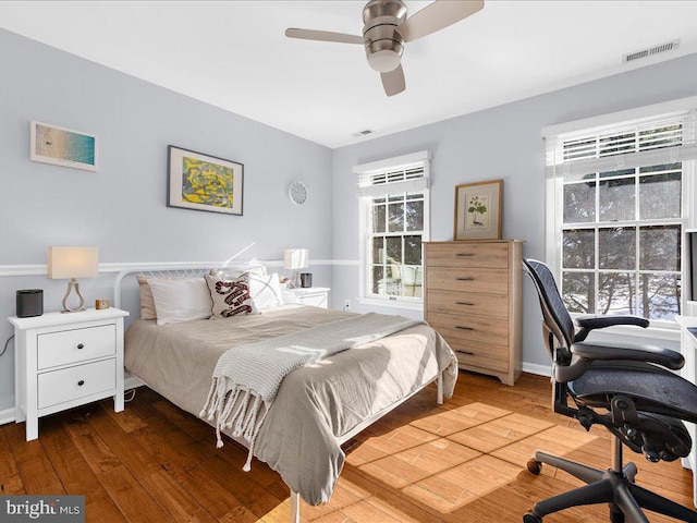 bedroom with dark hardwood / wood-style floors and ceiling fan