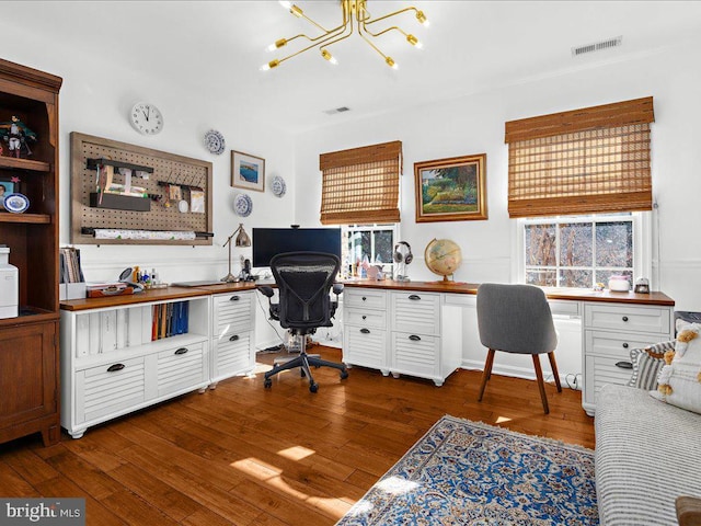 office area with a notable chandelier, dark wood-type flooring, and built in desk