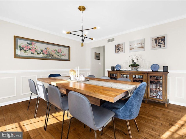 dining space featuring crown molding, dark hardwood / wood-style floors, and a chandelier