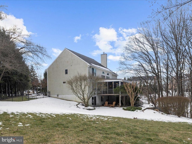 snow covered property featuring a yard and a sunroom