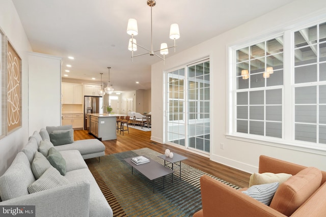 living room featuring an inviting chandelier and light wood-type flooring