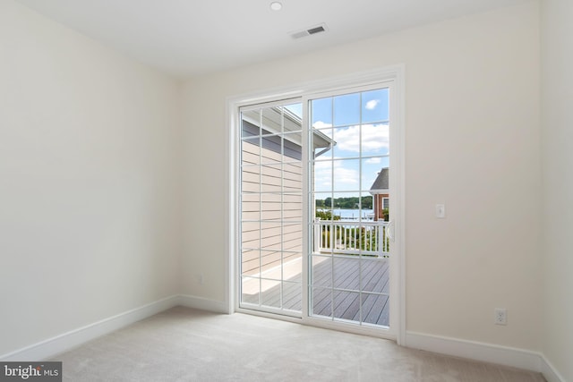 doorway to outside featuring light colored carpet