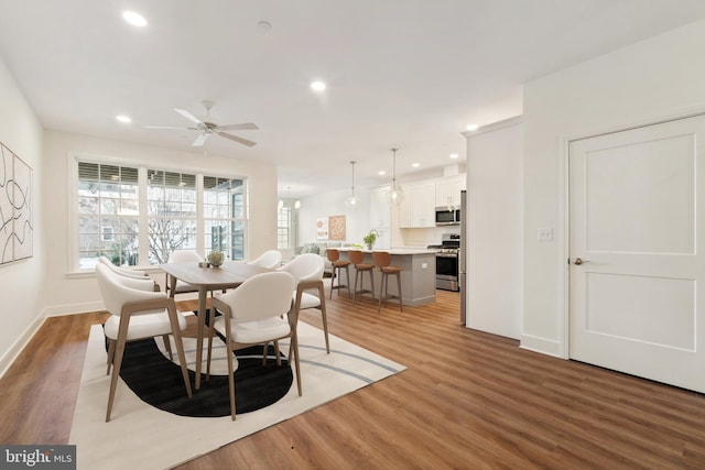 dining space with ceiling fan and hardwood / wood-style floors