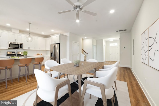 dining area with dark hardwood / wood-style floors and ceiling fan