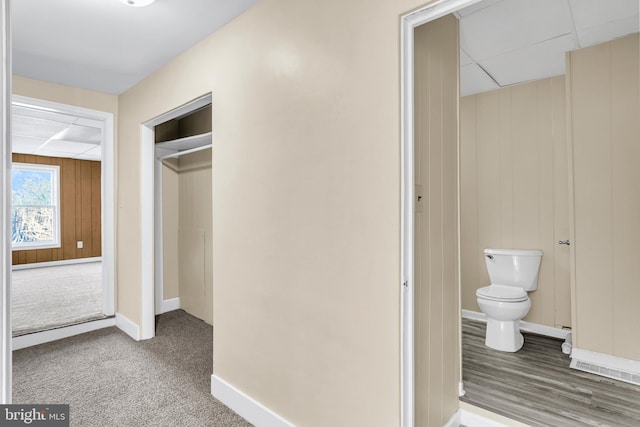 interior space with dark carpet and wood walls