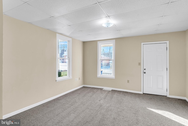 empty room with a paneled ceiling and carpet flooring