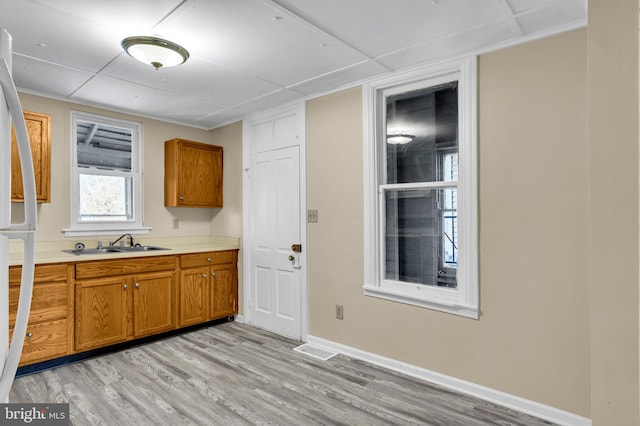 kitchen featuring white fridge, light hardwood / wood-style floors, and sink