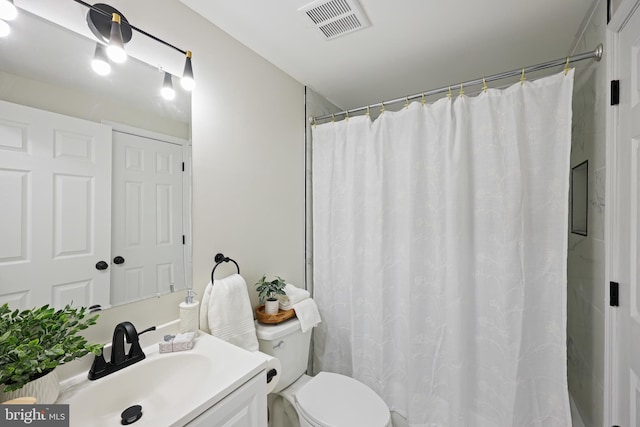 bathroom with curtained shower, toilet, and vanity