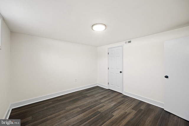 unfurnished room featuring dark wood-type flooring