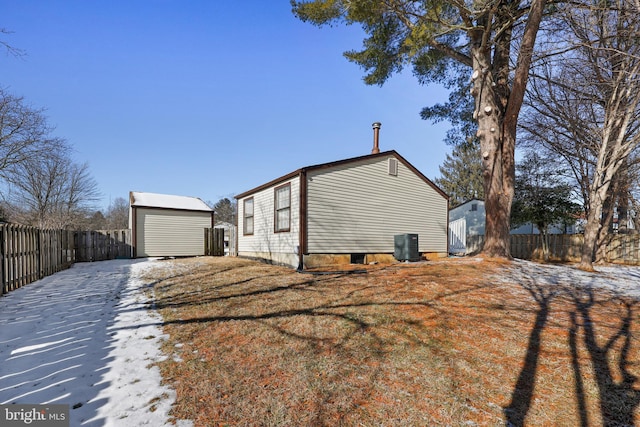 view of side of home featuring an outdoor structure, central AC, and a garage