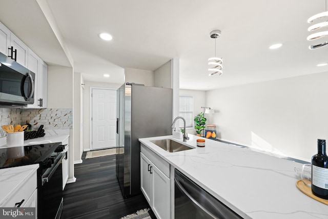 kitchen with white cabinets, appliances with stainless steel finishes, sink, hanging light fixtures, and light stone counters