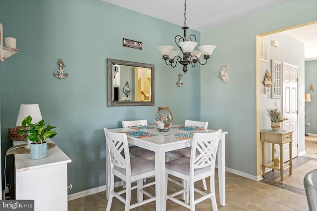 tiled dining area featuring a chandelier