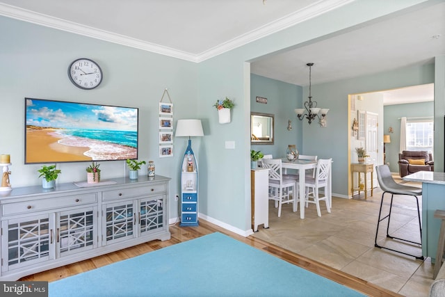 living room featuring ornamental molding, a notable chandelier, and light hardwood / wood-style flooring