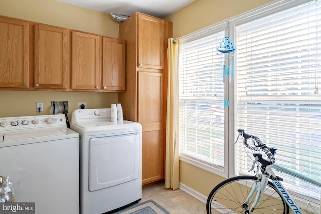 washroom featuring cabinets and washing machine and clothes dryer