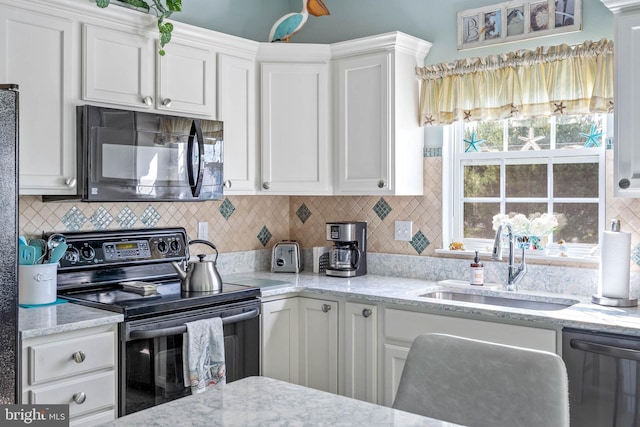 kitchen featuring sink, white cabinets, backsplash, and black appliances