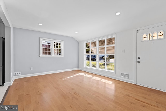 foyer entrance featuring vaulted ceiling and light wood-type flooring