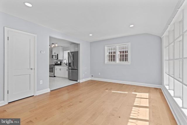 spare room featuring sink and light hardwood / wood-style flooring