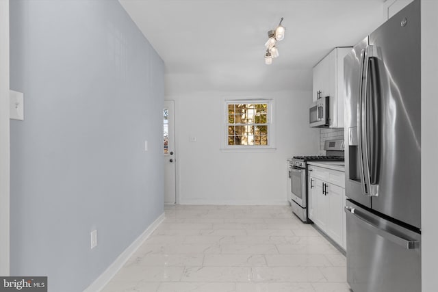 kitchen with tasteful backsplash, appliances with stainless steel finishes, and white cabinetry