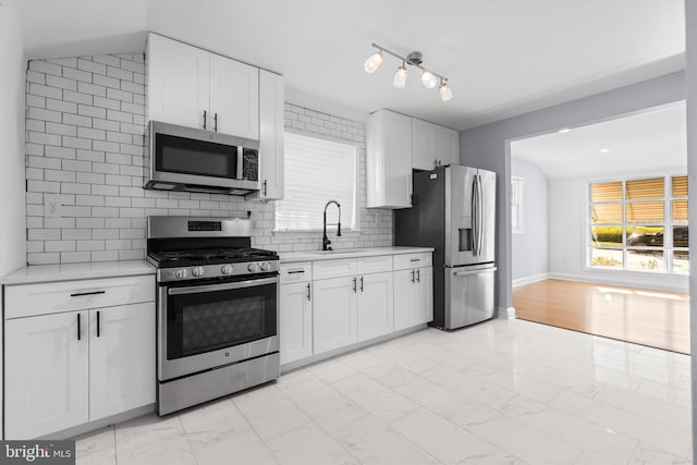 kitchen with sink, white cabinets, and stainless steel appliances