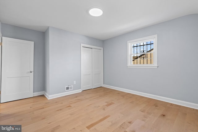 unfurnished bedroom featuring light hardwood / wood-style flooring and a closet