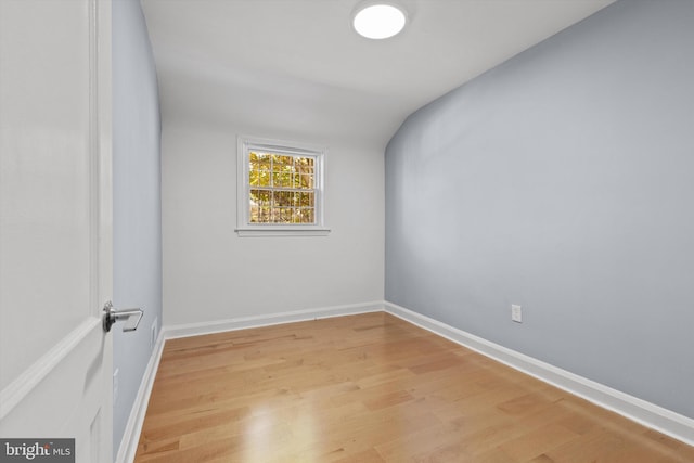 unfurnished room with light hardwood / wood-style flooring and lofted ceiling