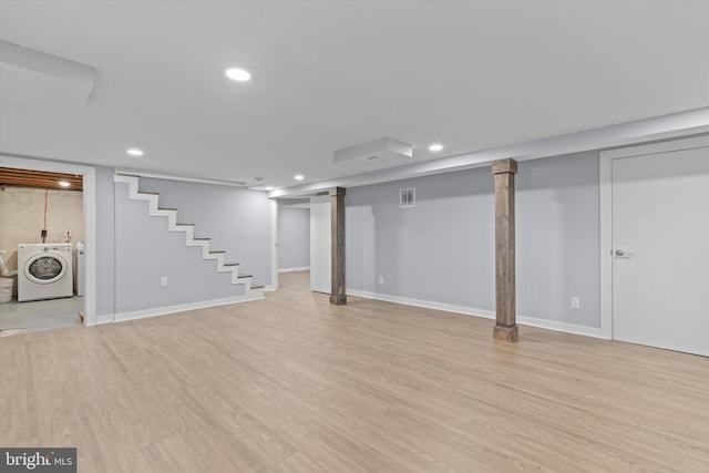 basement featuring washer and clothes dryer and light hardwood / wood-style flooring