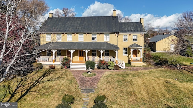 view of front of home with covered porch and a front lawn