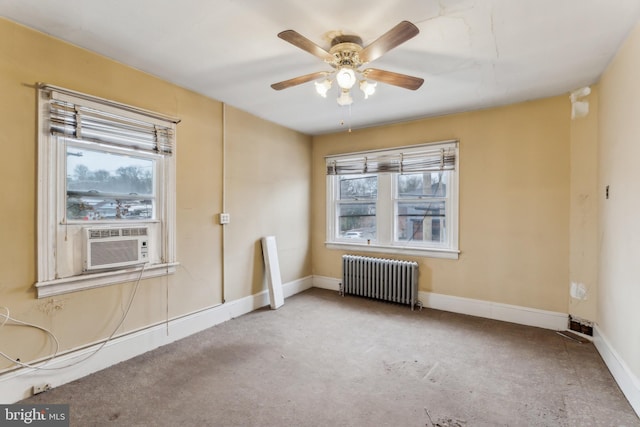 unfurnished room featuring ceiling fan, light colored carpet, cooling unit, and radiator