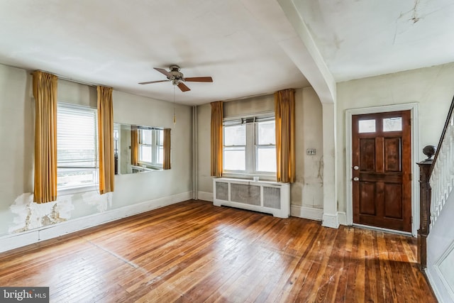 entrance foyer with ceiling fan, dark hardwood / wood-style flooring, and radiator heating unit