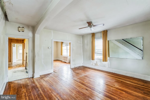 empty room with ceiling fan, wood-type flooring, and radiator