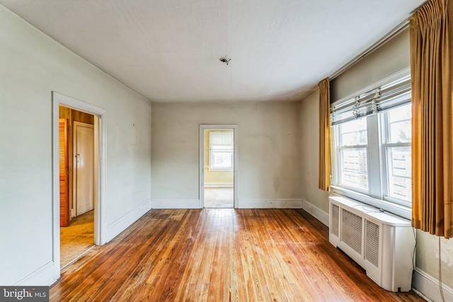 spare room featuring hardwood / wood-style flooring and radiator