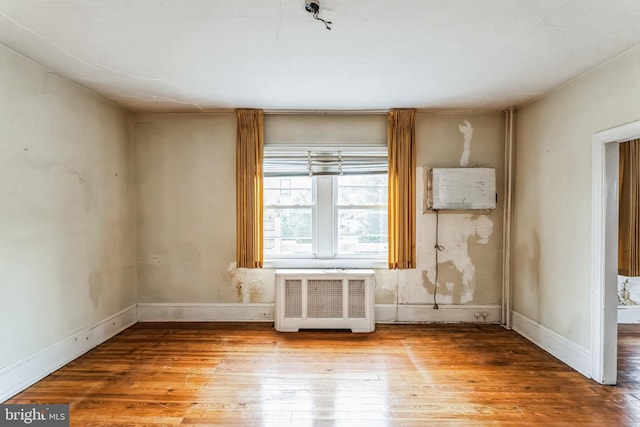 misc room with wood-type flooring and radiator heating unit