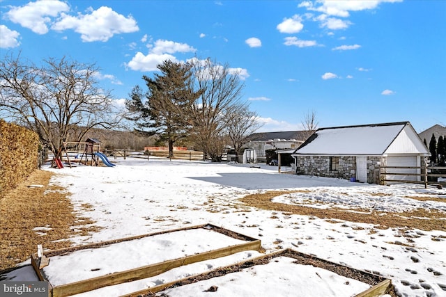 yard layered in snow featuring a playground