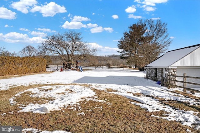 yard layered in snow featuring a playground