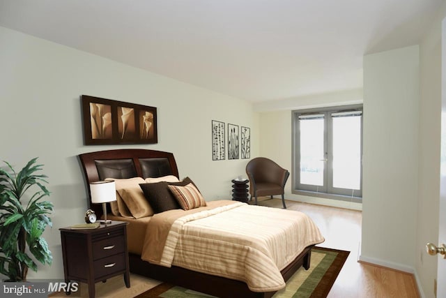 bedroom with light hardwood / wood-style floors and french doors