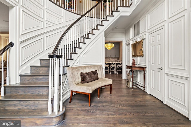 stairway featuring ornamental molding, a chandelier, and hardwood / wood-style flooring