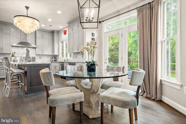 dining area featuring plenty of natural light, dark hardwood / wood-style flooring, sink, and a notable chandelier