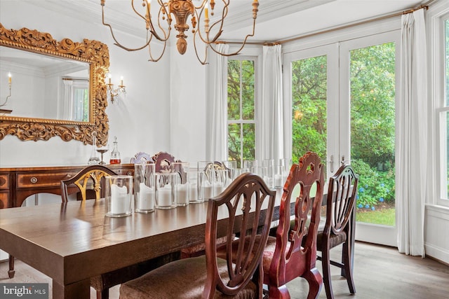 dining space featuring ornamental molding, hardwood / wood-style floors, and a notable chandelier