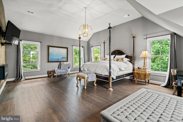 bedroom with lofted ceiling, an inviting chandelier, and hardwood / wood-style flooring