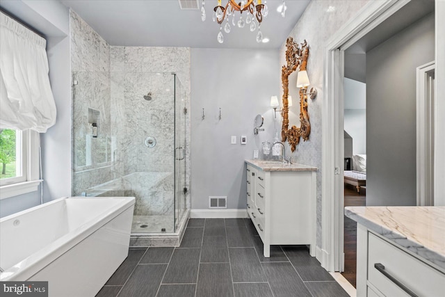 bathroom with shower with separate bathtub, vanity, and a notable chandelier