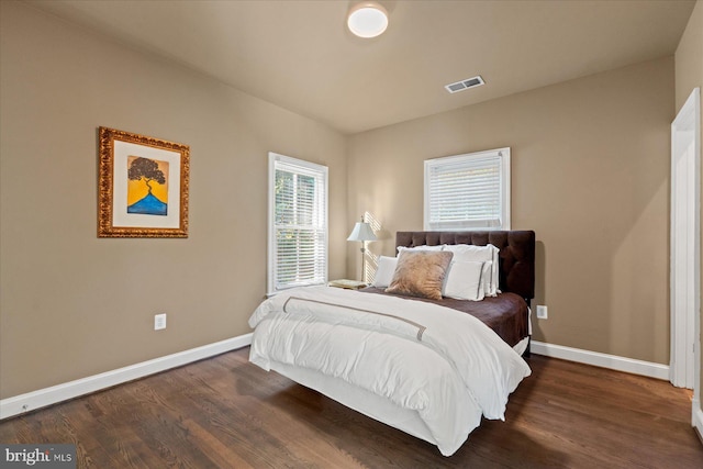 bedroom with dark hardwood / wood-style flooring