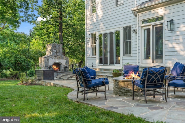 view of patio / terrace with an outdoor stone fireplace and a fire pit