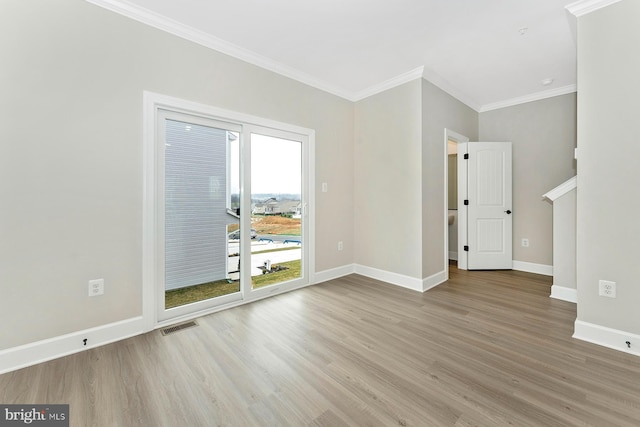 spare room featuring crown molding and light hardwood / wood-style flooring