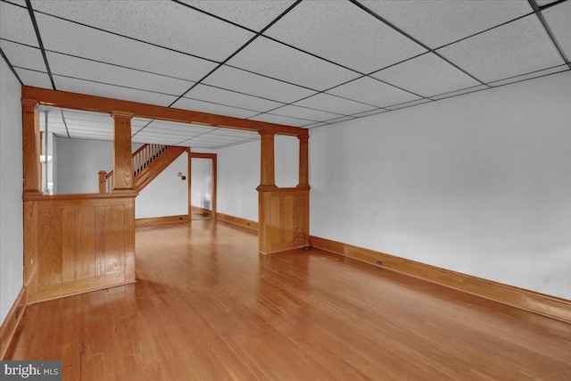 basement featuring wood-type flooring and a drop ceiling