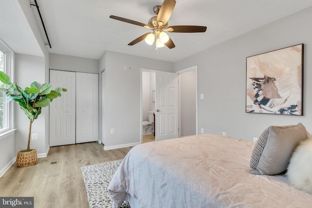 bedroom with ceiling fan, light hardwood / wood-style floors, and ensuite bath