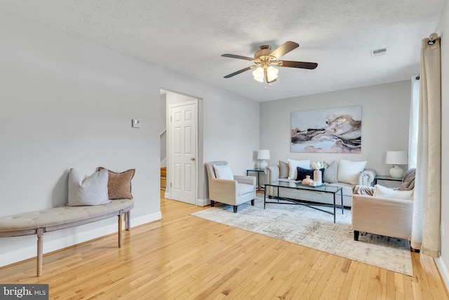 sitting room with ceiling fan, a textured ceiling, and hardwood / wood-style floors