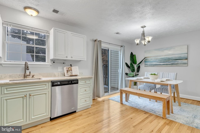 kitchen with light hardwood / wood-style floors, sink, hanging light fixtures, and dishwasher