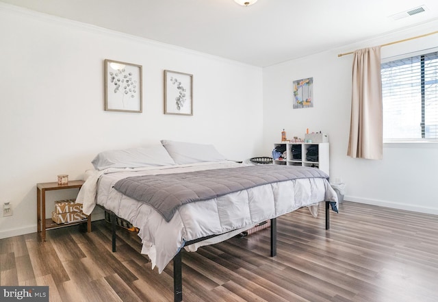 bedroom featuring ornamental molding and dark hardwood / wood-style floors