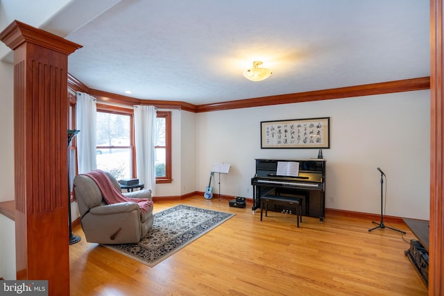 living area with light hardwood / wood-style flooring and crown molding