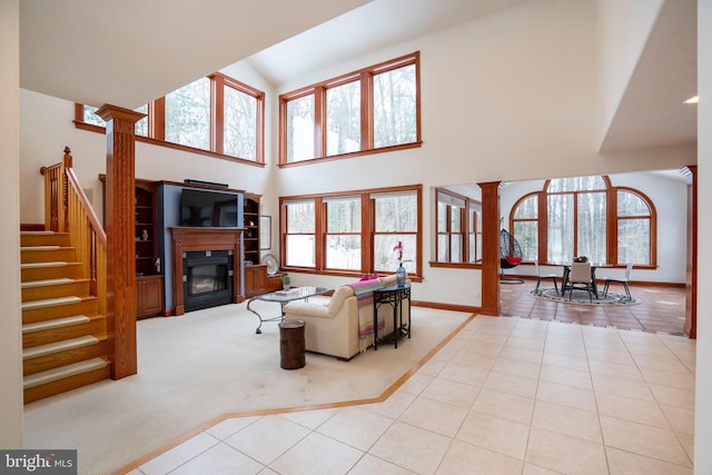 tiled living room featuring decorative columns and a high ceiling